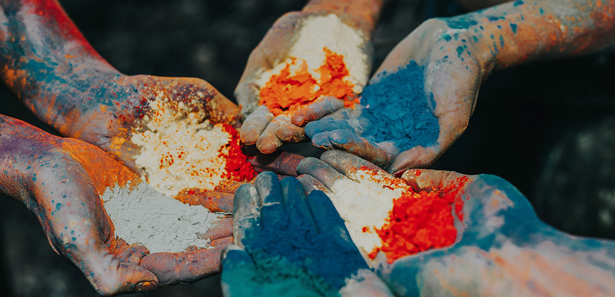 A group of people with their hands covered in coloured powder